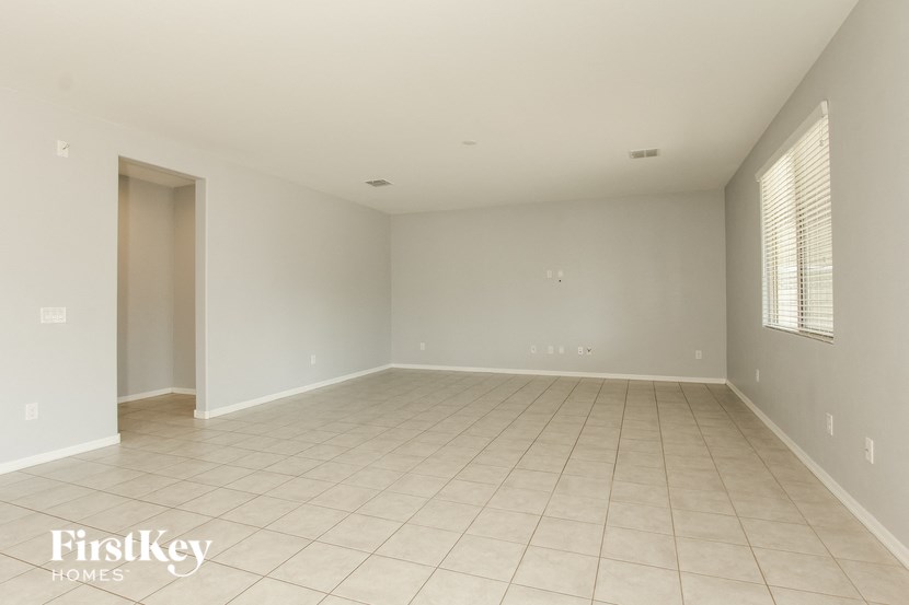 an empty living room with tiled floors and white walls