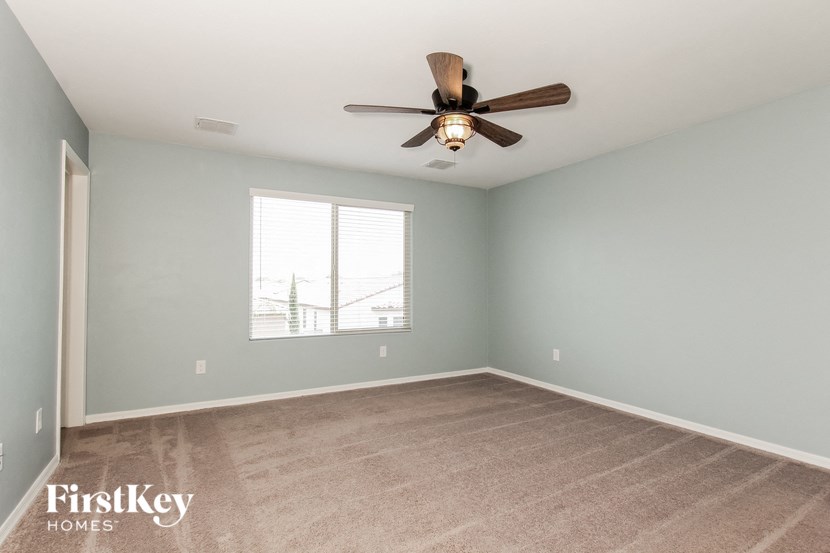 a bedroom with a ceiling fan and a window