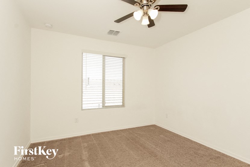 the living room of an empty home with a ceiling fan