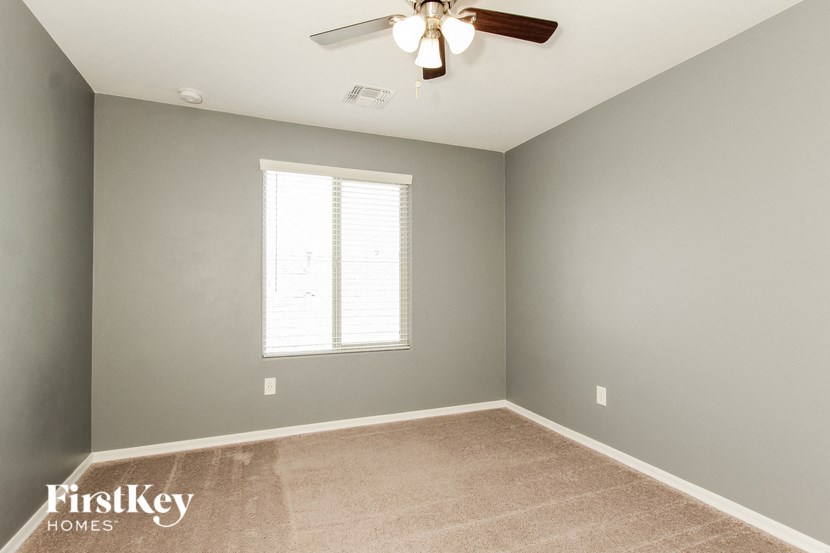 a empty room with a ceiling fan and a window
