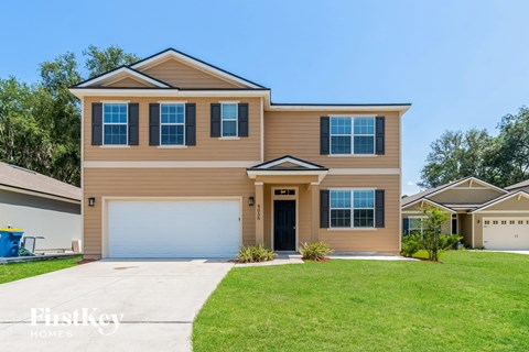 a house with a garage door and a lawn