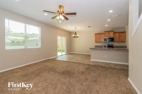 an empty kitchen and living room with a ceiling fan