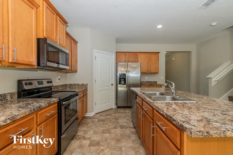 a kitchen with granite counter tops and wooden cabinets
