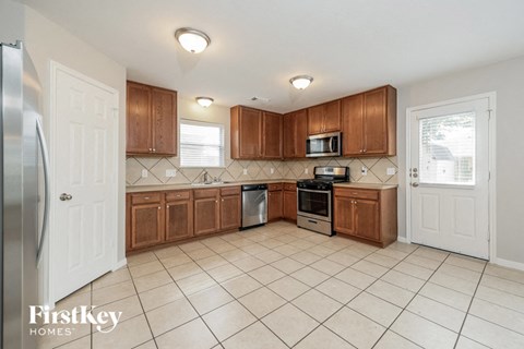 A kitchen with wooden cabinets and a tiled floor.