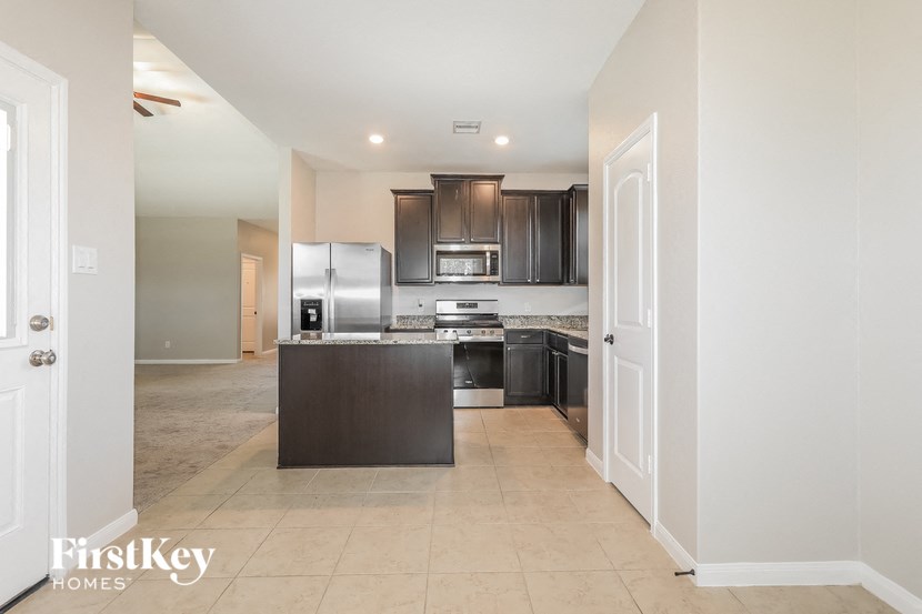 a large kitchen with a refrigerator and a sink