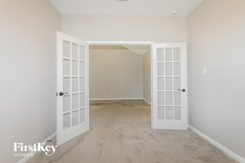 a bedroom with two doors and a carpeted floor