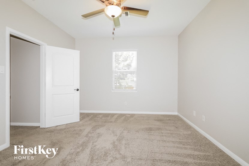 a bedroom with carpet and a ceiling fan