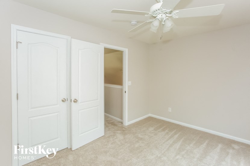 A room with a ceiling fan and two doors.