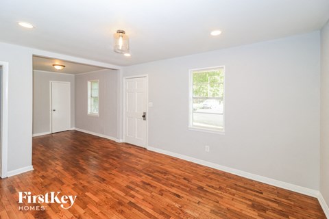 the living room with hardwood flooring and a window