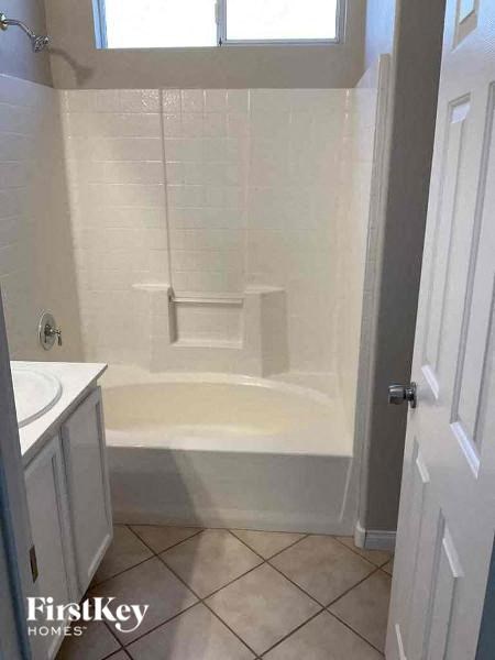 a white bathroom with a shower and a sink