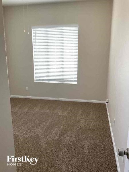 an empty room with a window and a carpeted floor