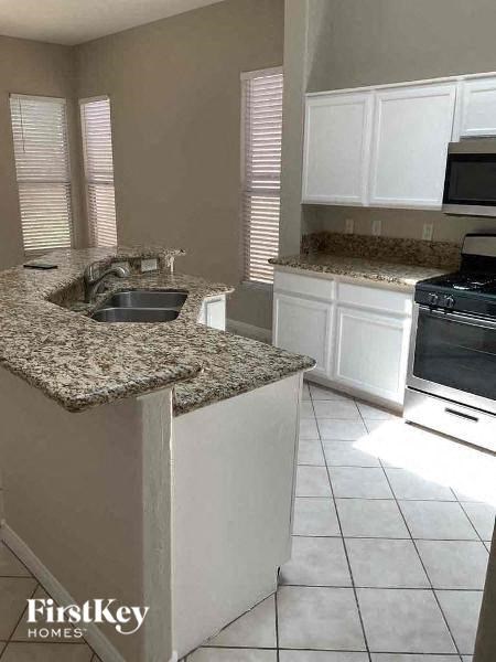 a kitchen with white cabinets and granite counter tops