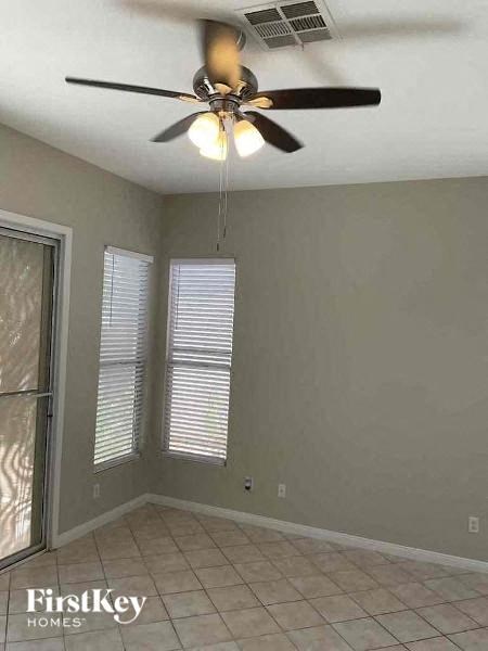 a living room with a ceiling fan and a tiled floor