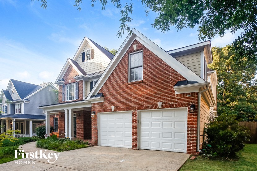 A brick house with a white garage door is for sale.