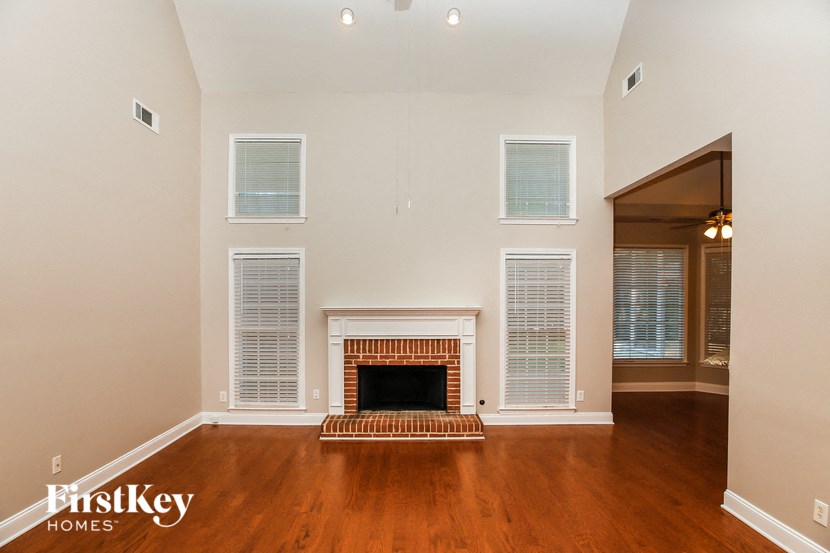 A living room with a fireplace and a doorway leading to another room.