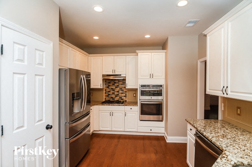 A kitchen with a tile backsplash and stainless steel appliances.