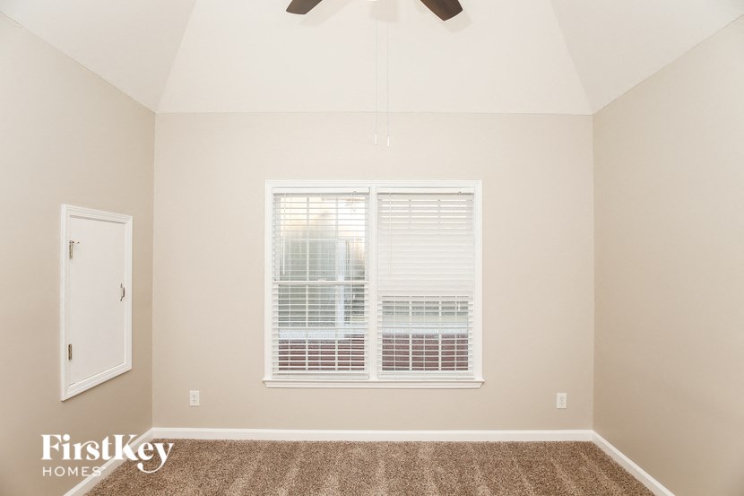 A room with a window and a carpet on the floor.