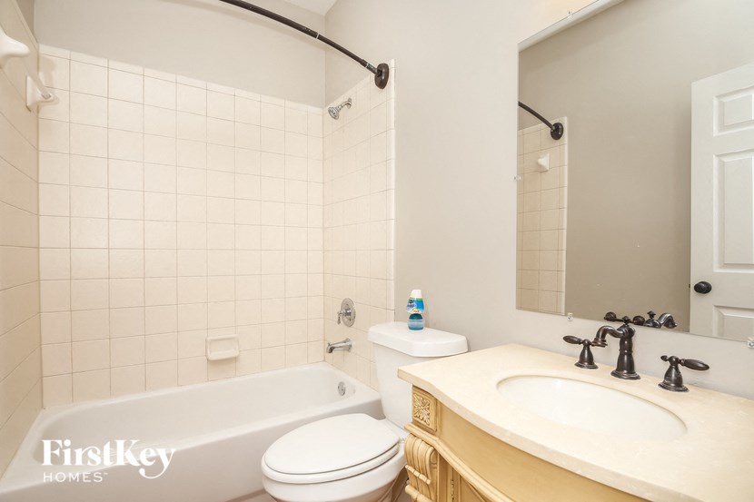 A white toilet sits next to a bathtub in a bathroom.