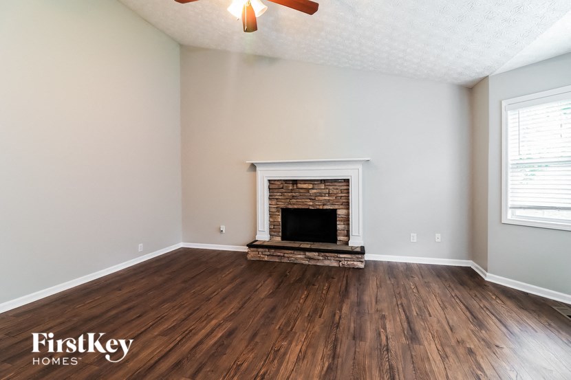 A room with a fireplace and wooden floors.