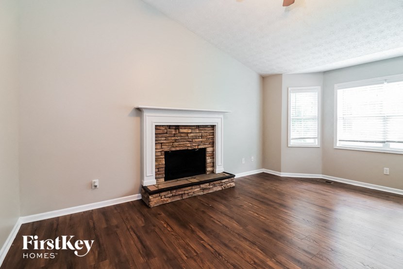 A room with a fireplace and wooden floors.