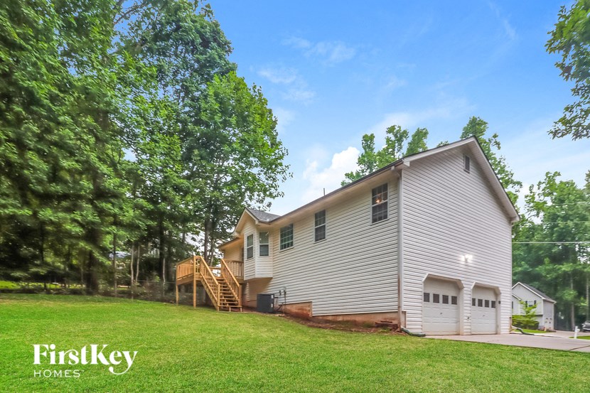 A house with a garage and a tree in front of it.