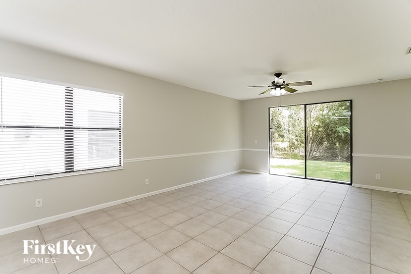 A spacious room with a ceiling fan and sliding glass doors.