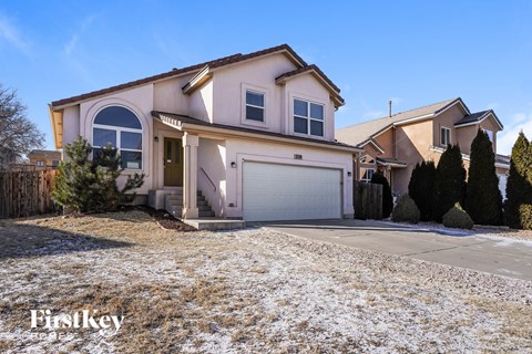 a house with a snow covered driveway and a garage door