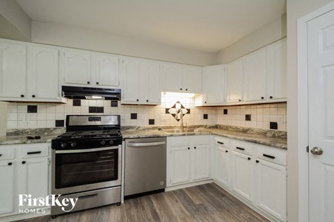 a kitchen with white cabinets and stainless steel appliances