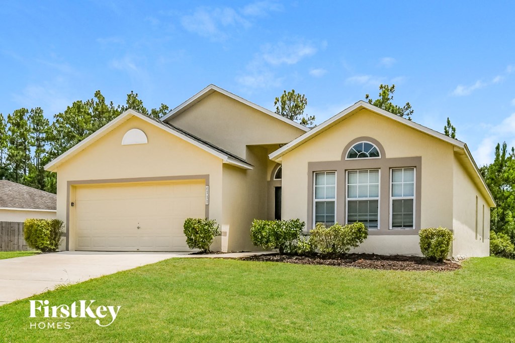 a beige house with a lawn in front of it