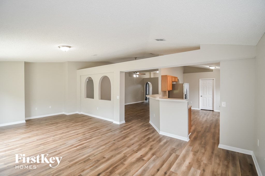 an open living room and kitchen with wood flooring