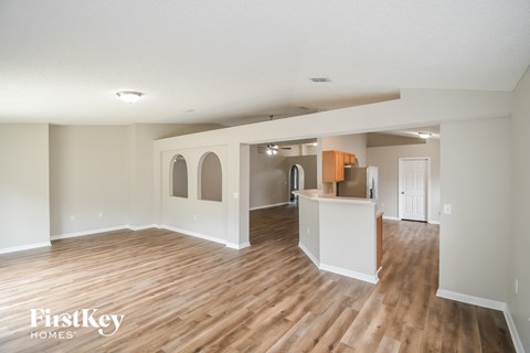 an open living room and kitchen with wood flooring