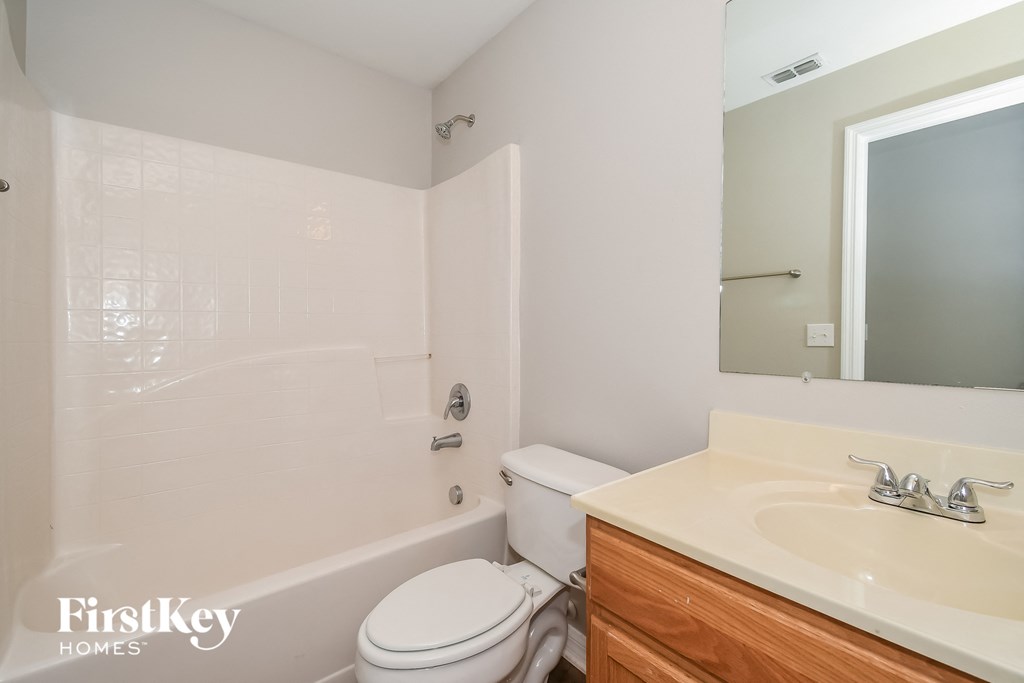 a bathroom with a sink toilet and tub and a mirror