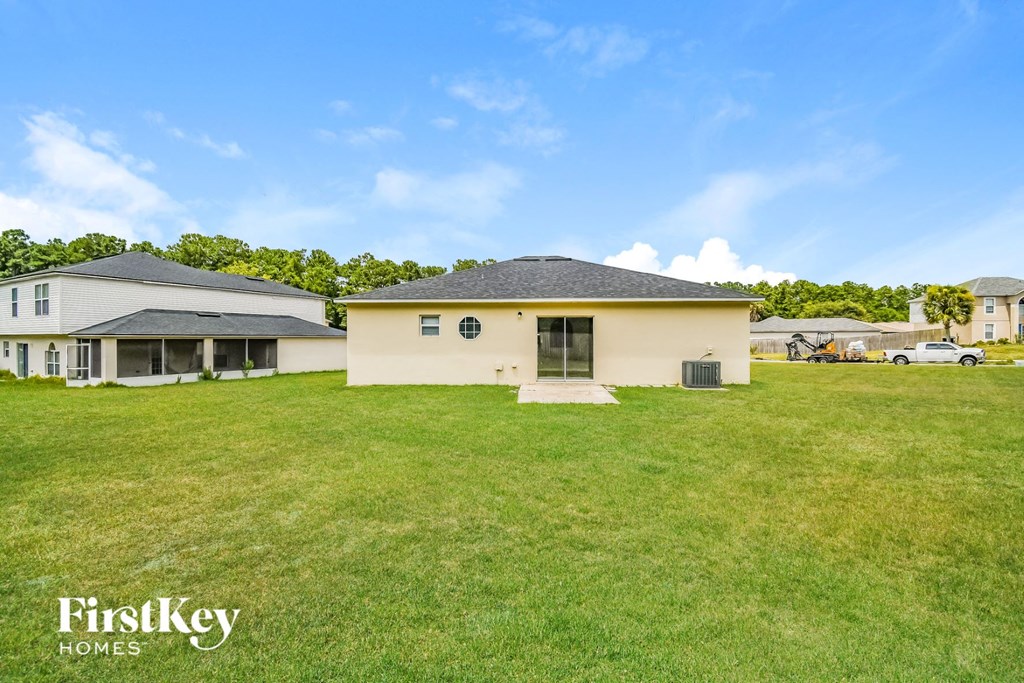 a backyard with a house and a green lawn