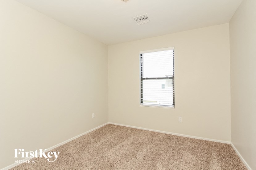 a spacious room with carpet and a window