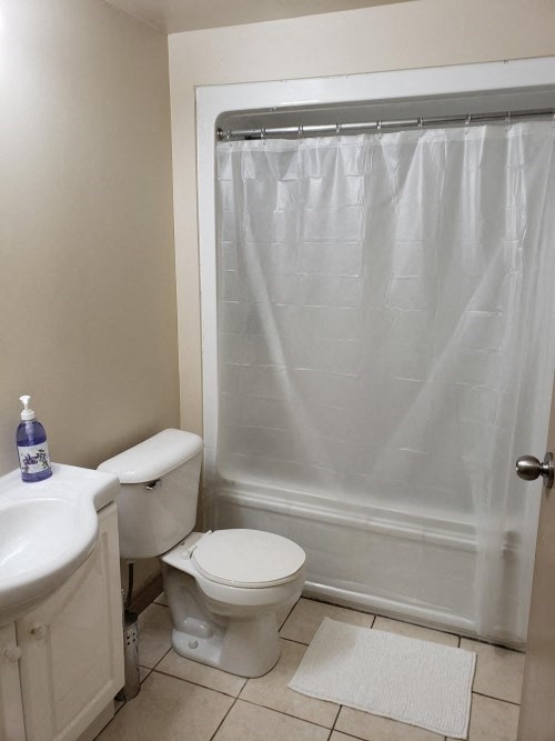 a bathroom with a toilet and a sink and a shower