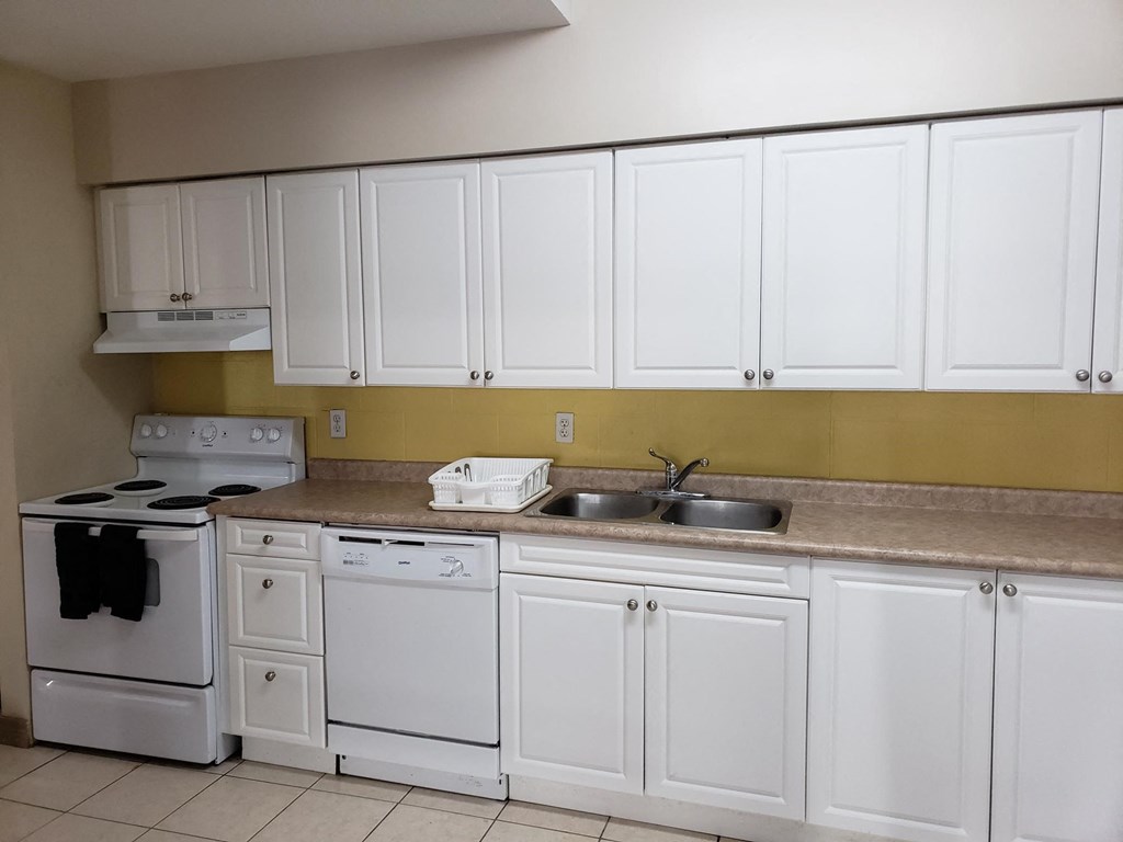 a kitchen with white cabinets and appliances and a sink