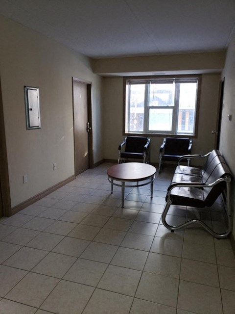 a living room with chairs and a table and a window