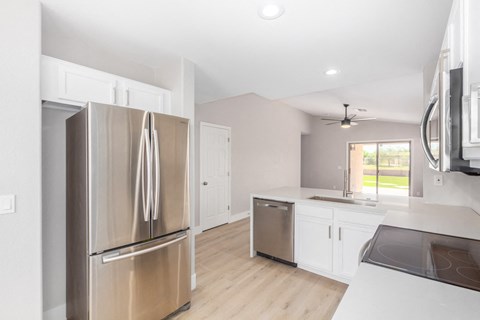 A modern kitchen with a stainless steel refrigerator and a dishwasher.