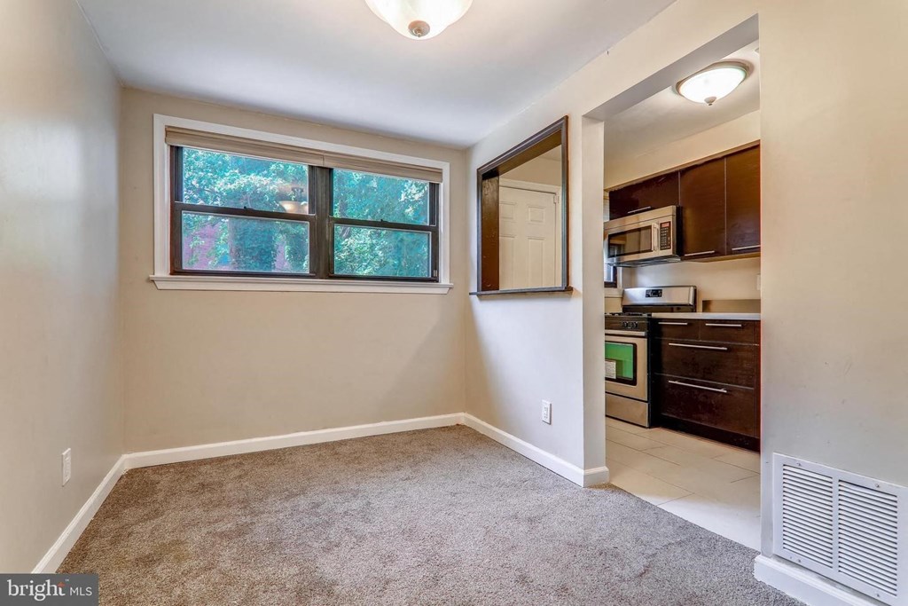 an empty room with a window and a kitchen