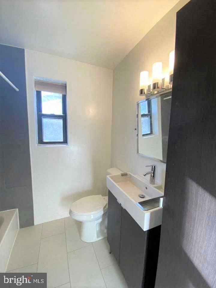 a bathroom with a toilet and a sink and a window