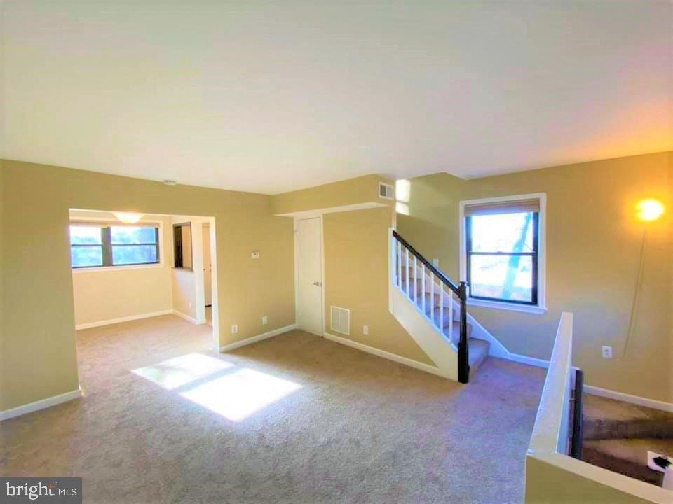 an empty living room with a staircase in a house