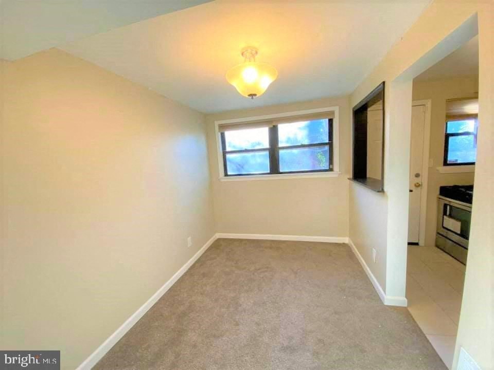 a empty living room with a window and a carpet
