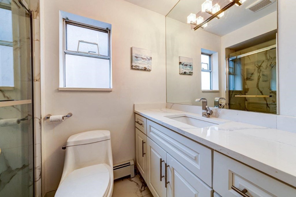 a bathroom with a toilet and a sink and a shower