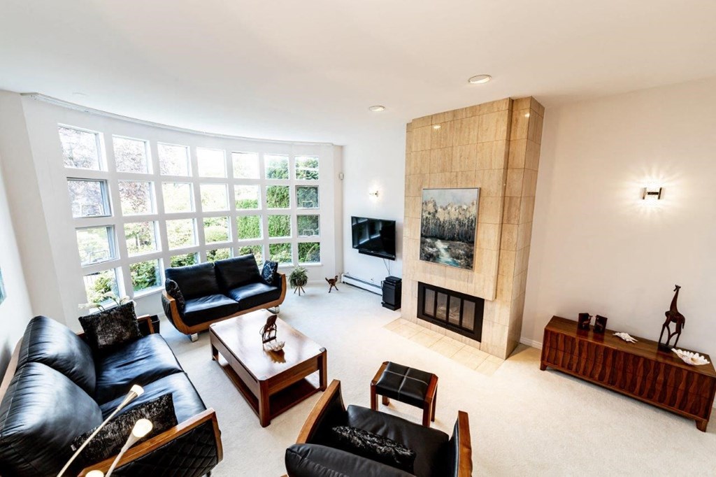 a living room with black leather furniture and a fireplace