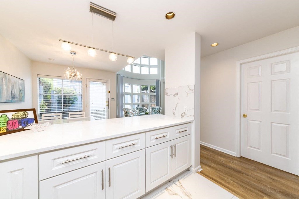 a large white kitchen with a large counter top