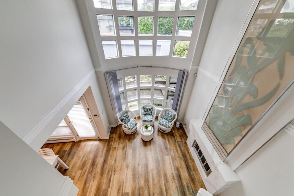 a living room with a high ceiling and a large window
