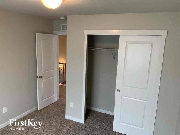 an empty bedroom with a closet and two doors
