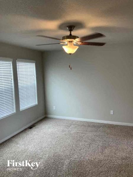 an empty room with a ceiling fan and a window