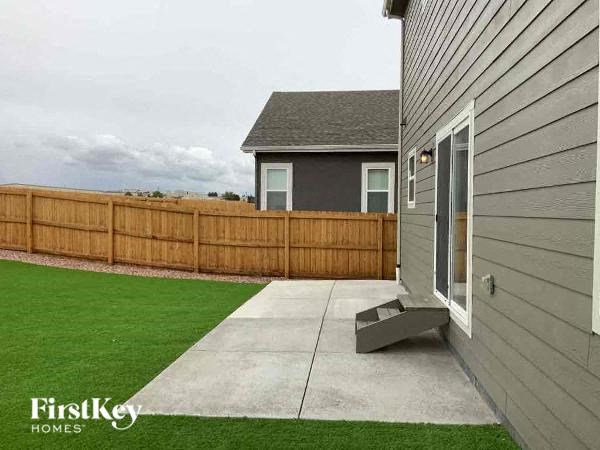 a backyard with a patio and a fence and a house