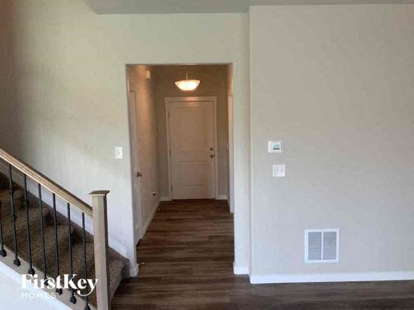 a hallway of a house with stairs and a door